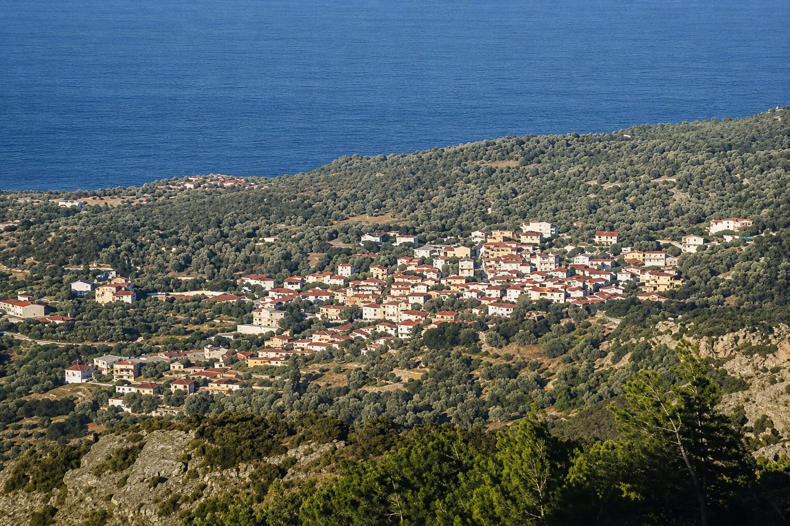 Θέα από τα Κουμαίικα Σάμου με παραδοσιακά σπίτια και ορίζοντα στο Αιγαίο.
