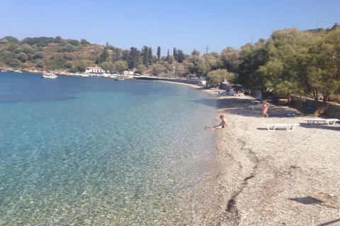 Agia Paraskevi Beach on Samos with a pebble shore and clear turquoise waters beyond Cape Kotsikas