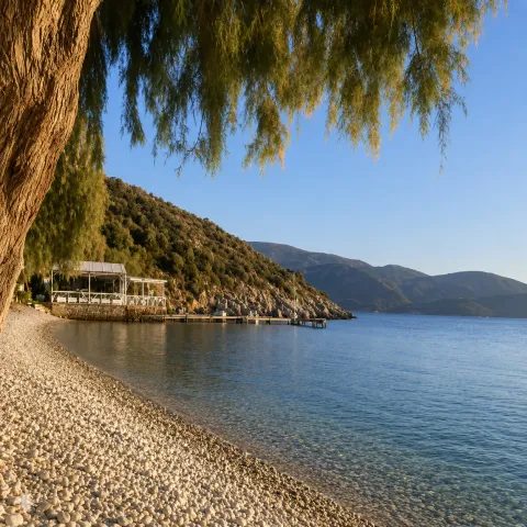 Παραλία Κλήμα στη Σάμο με γαλάζια νερά, δέντρα και ήσυχη ατμόσφαιρα
