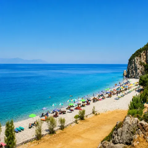 Strand Tsampou auf Samos mit großen Kieseln, tiefblauem Meer und Kiefern rund um die Bucht