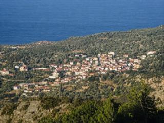 Θέα από τα Κουμαίικα Σάμου με παραδοσιακά σπίτια και ορίζοντα στο Αιγαίο.